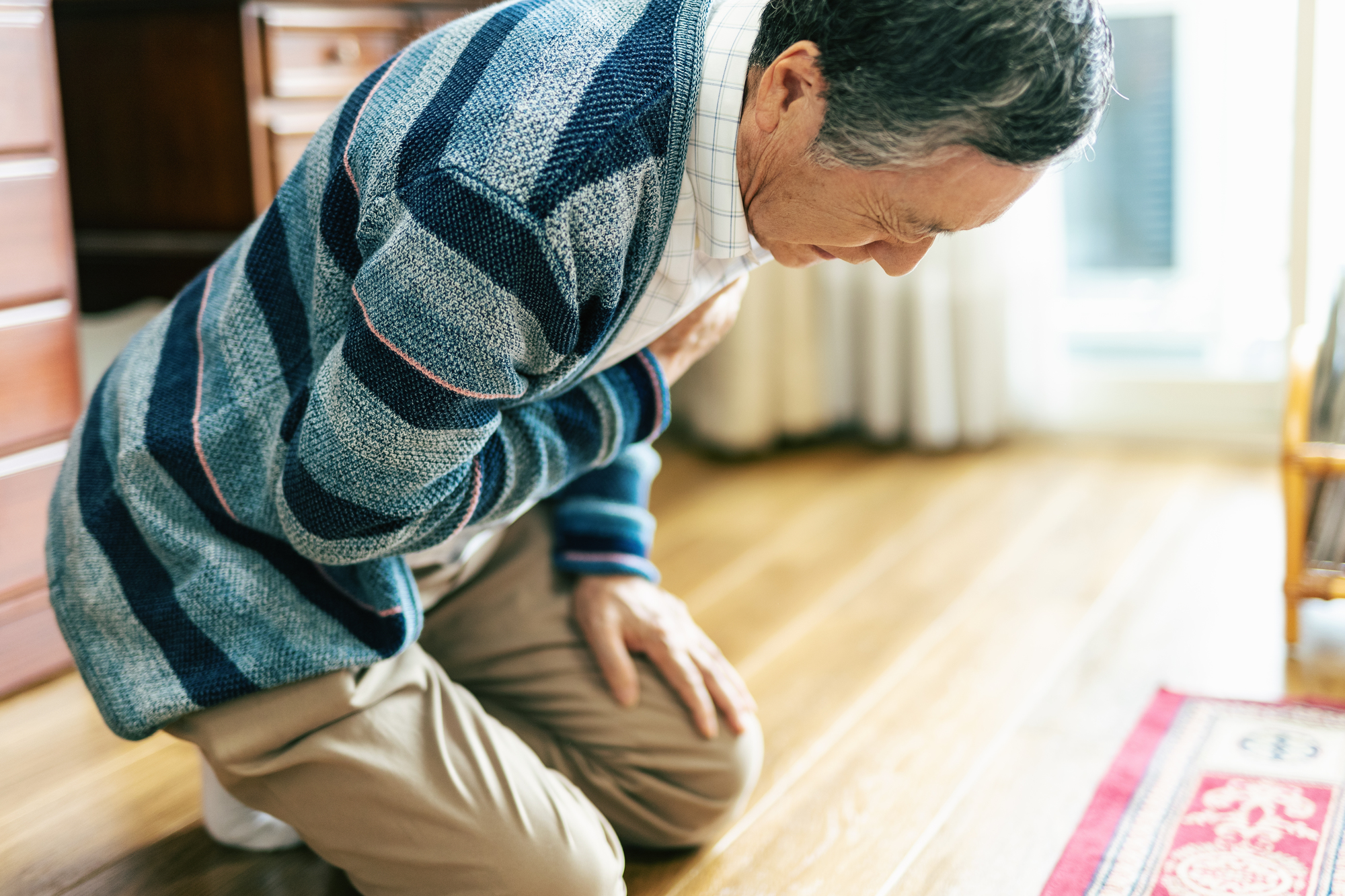 胸を押さえて苦しそうにしているシニア男性