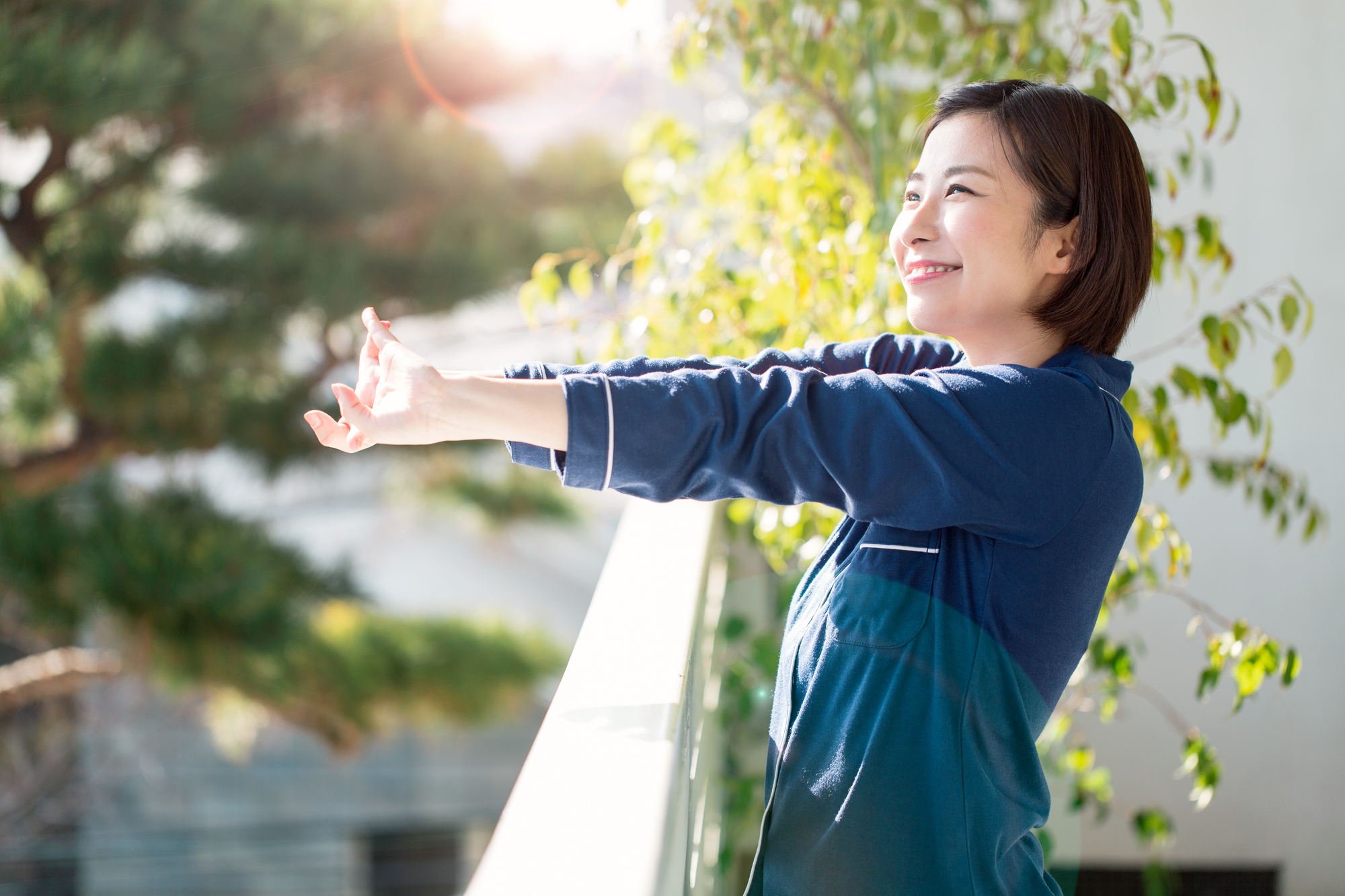 爽やかな朝の中、腕を伸ばしている女性