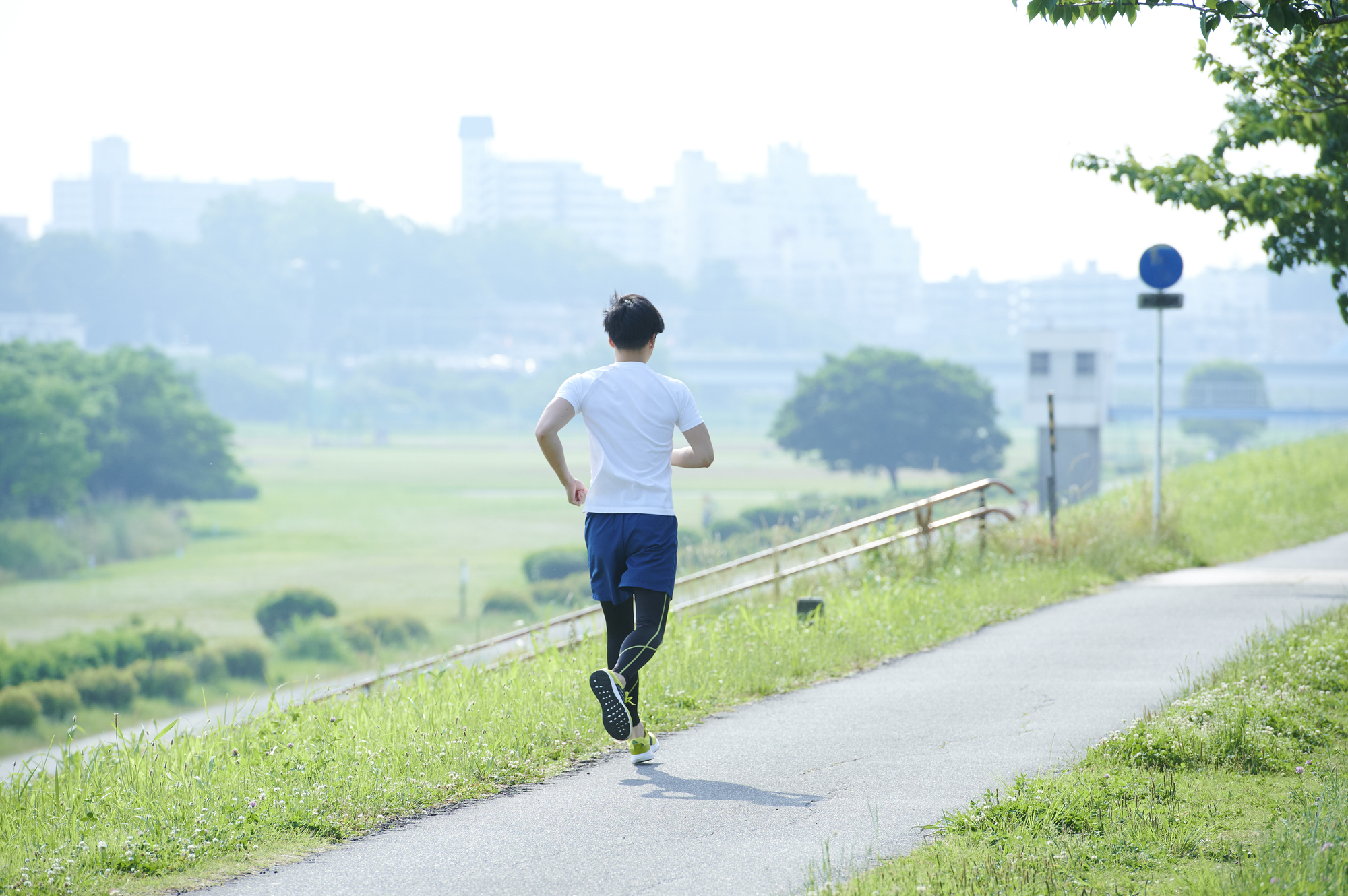 いい天気の中、土手を走っている男性