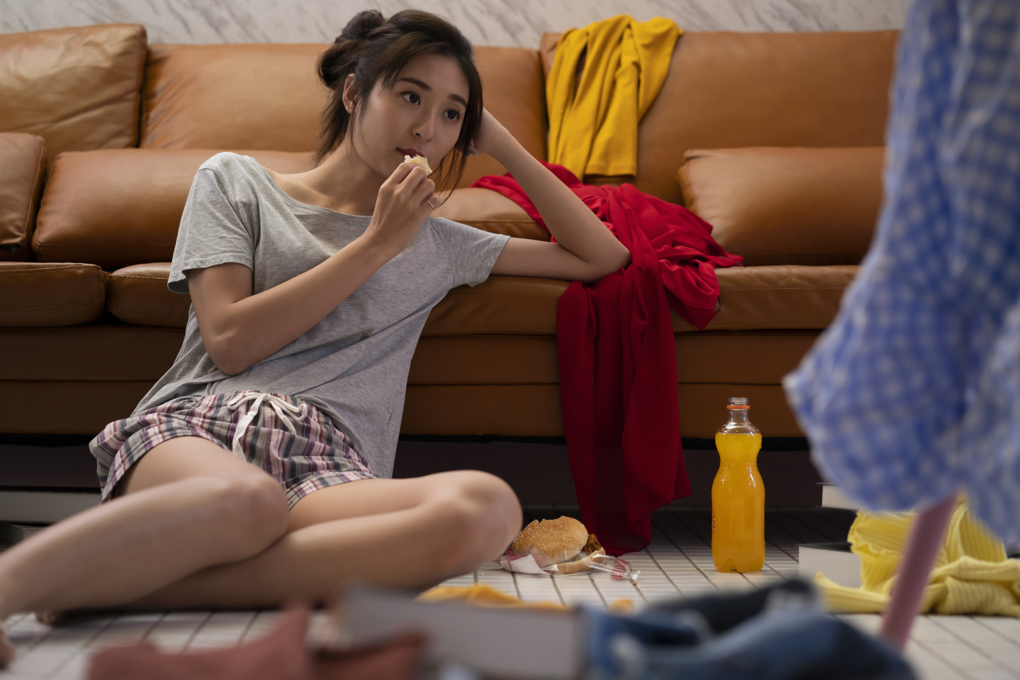 お菓子とジュースを食べている女性