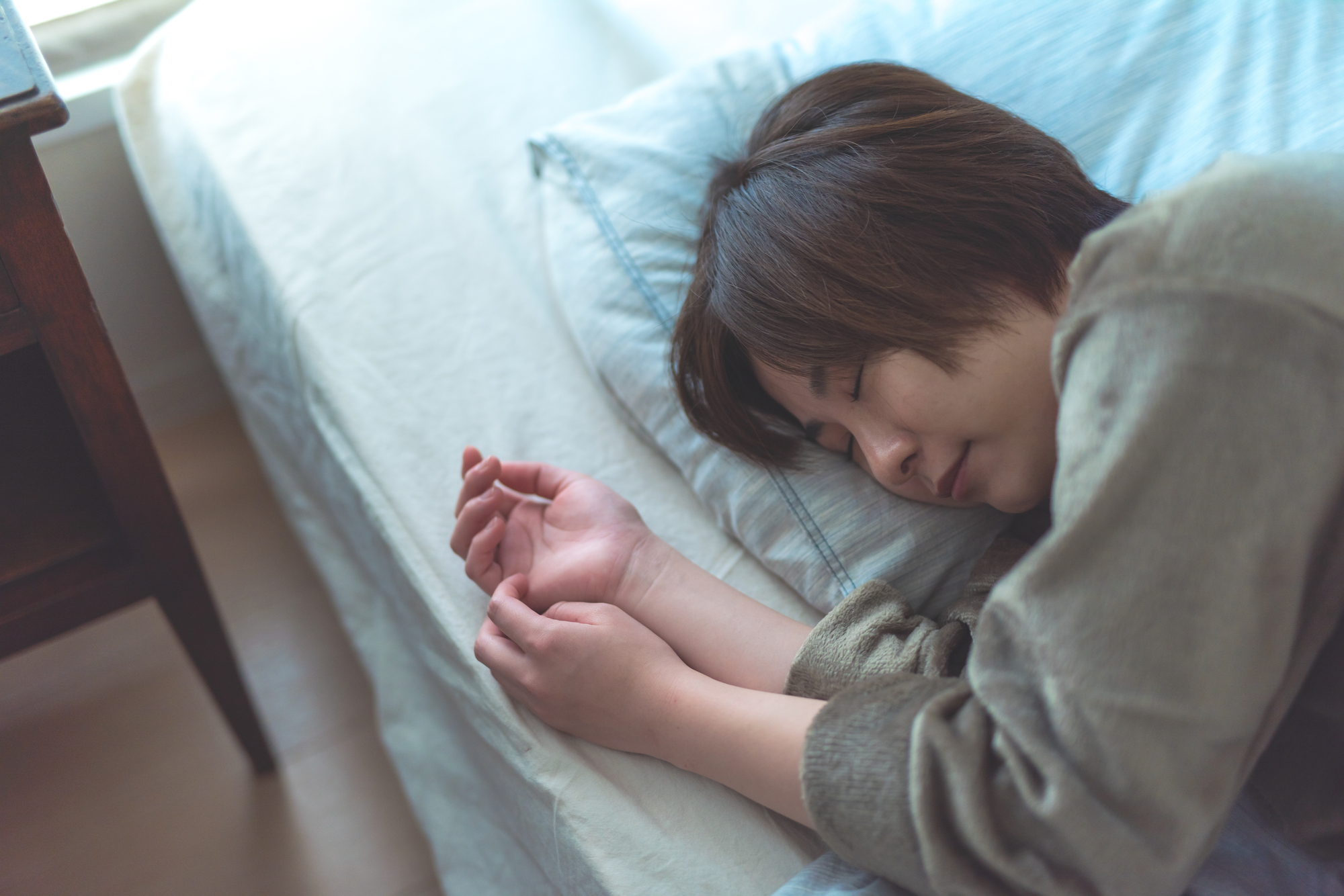 横向きで寝ている女性の写真