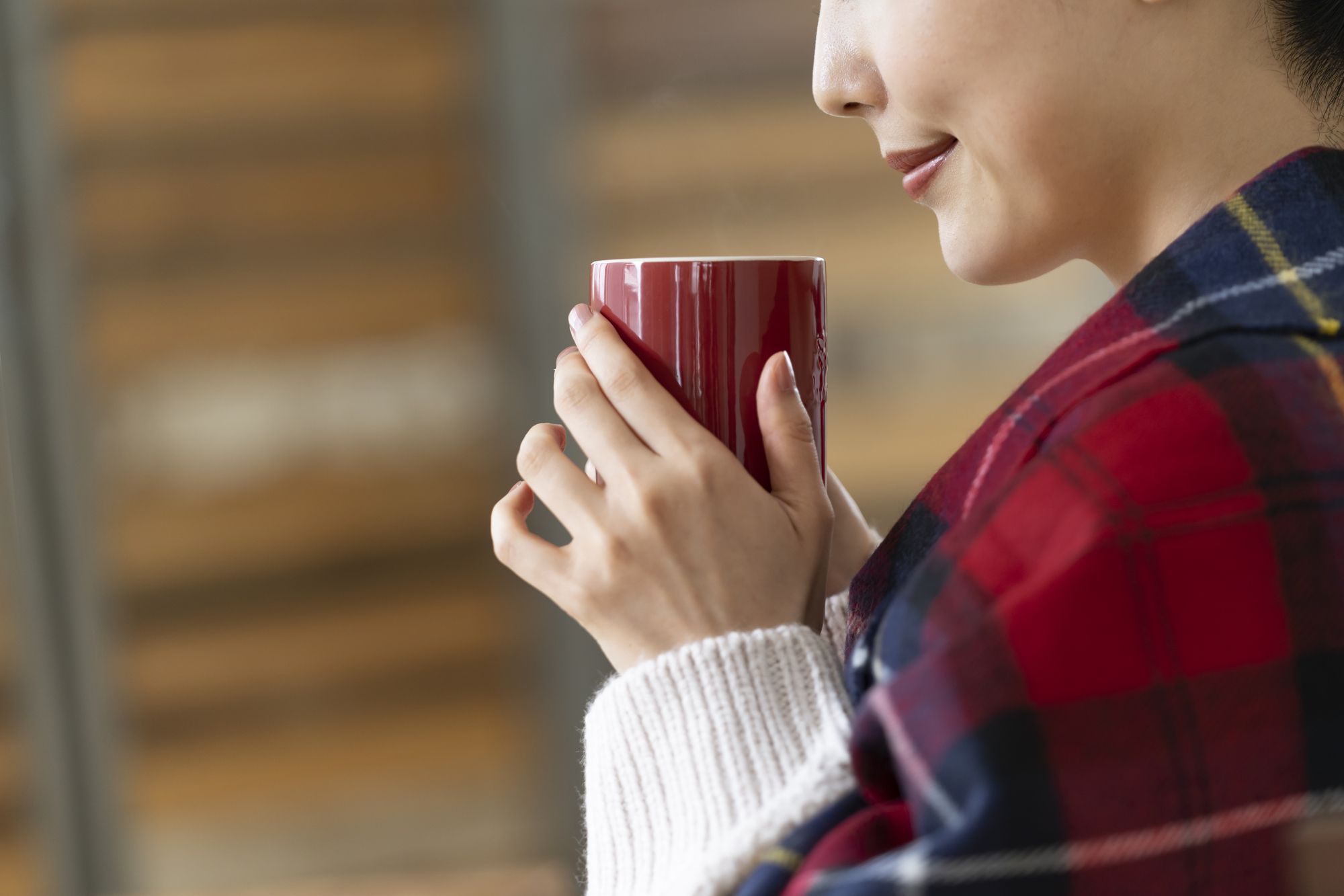 マグカップを持つ若い女性の手元