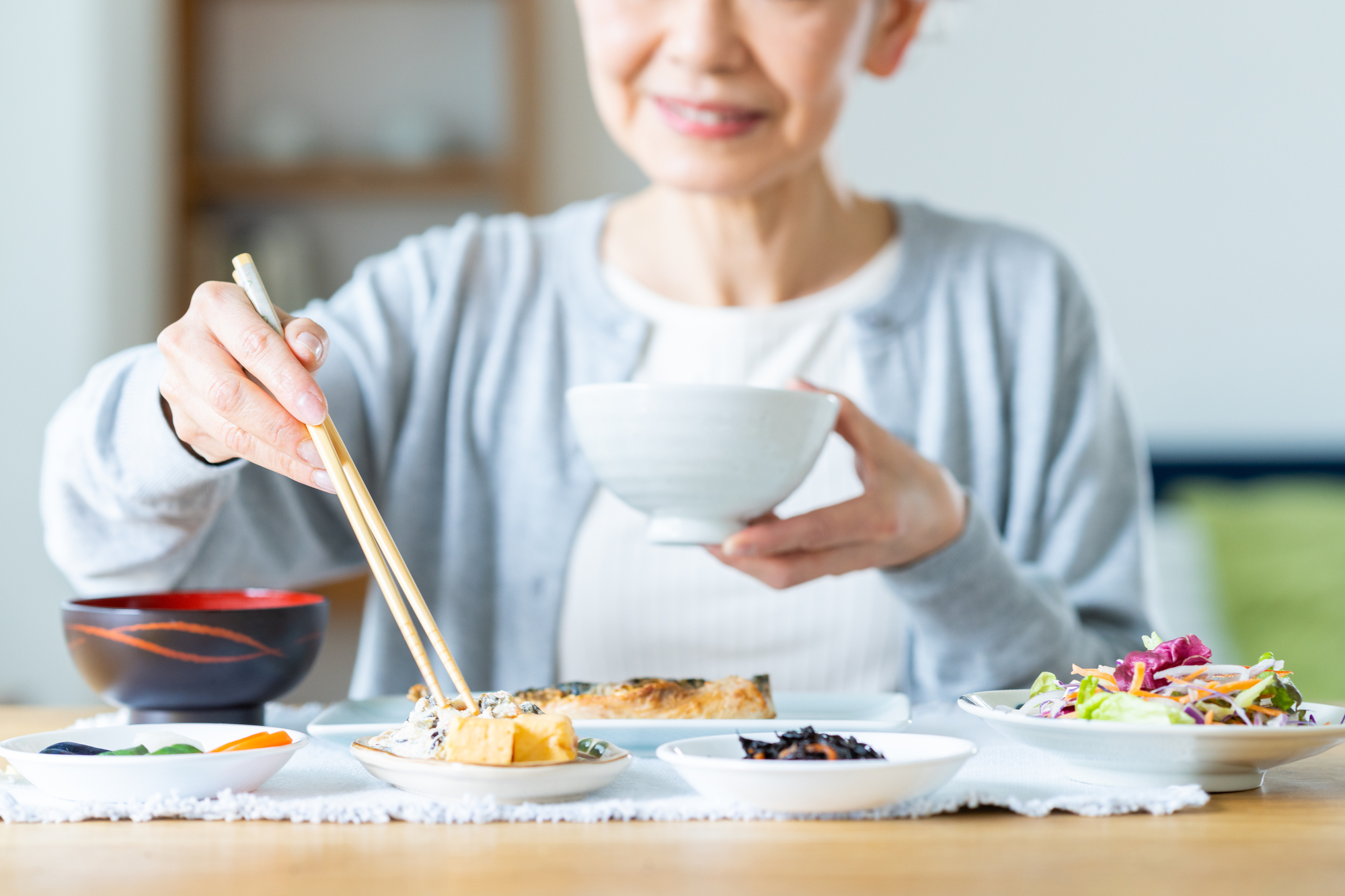 和食の朝ごはんを食べているシニア世代