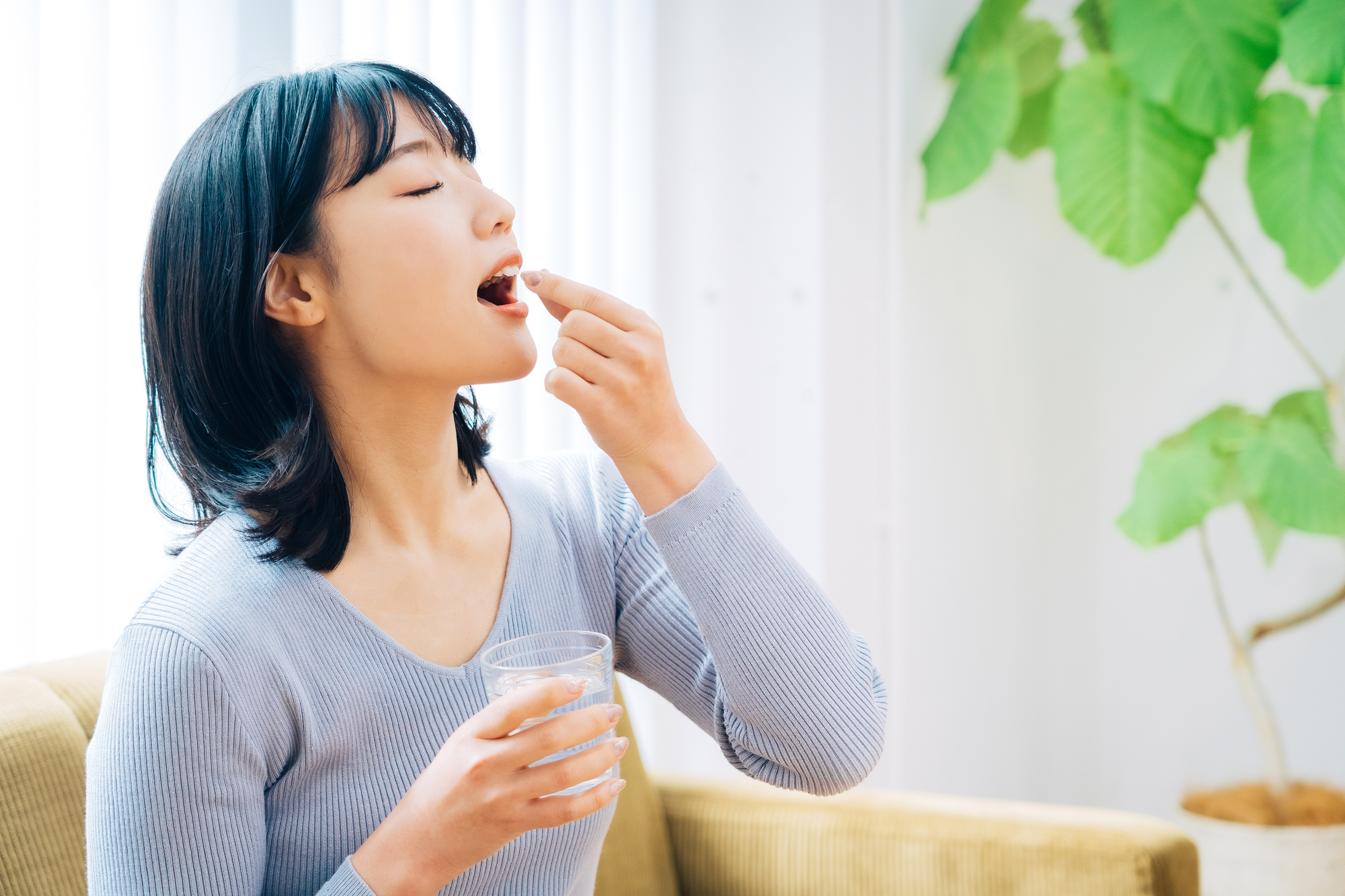 サプリメントを飲む女性