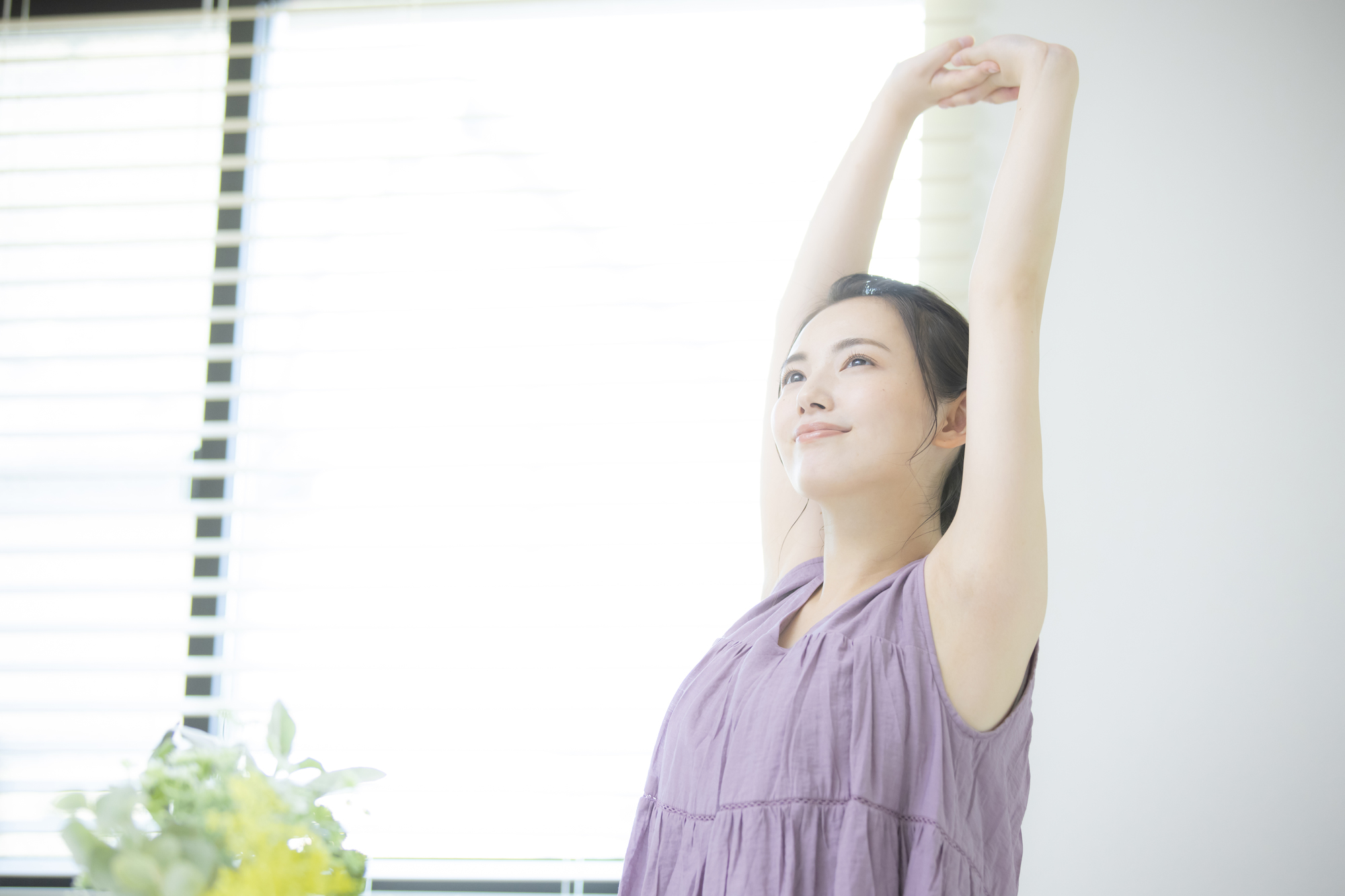 朝の目覚め、体を伸ばしている女性