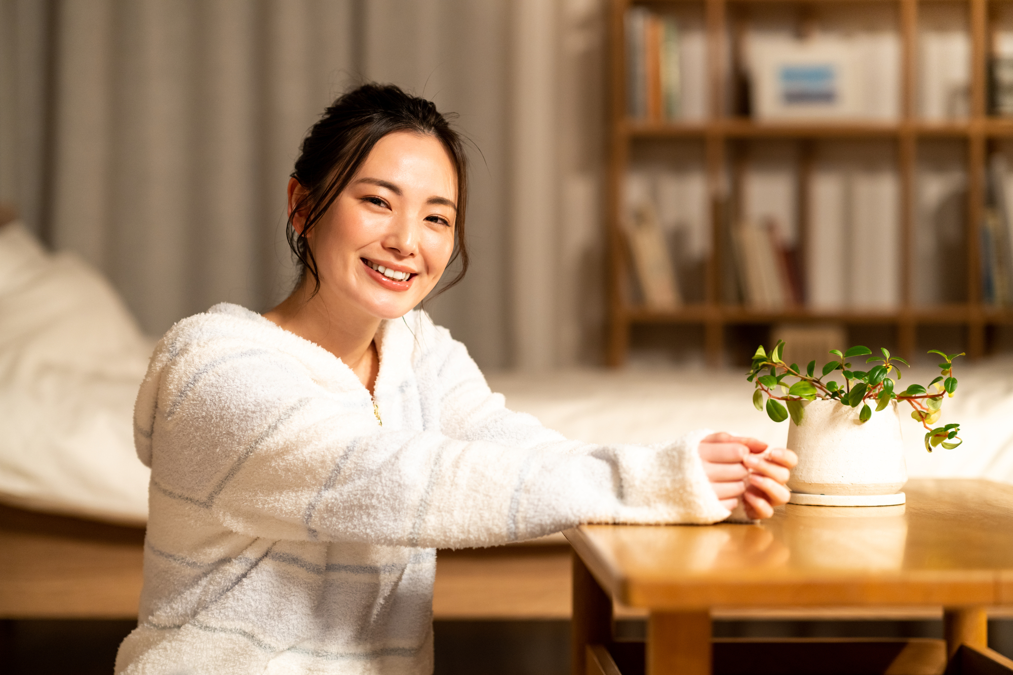 パジャマを着た女性がこちらを見てほほ笑んでいる様子