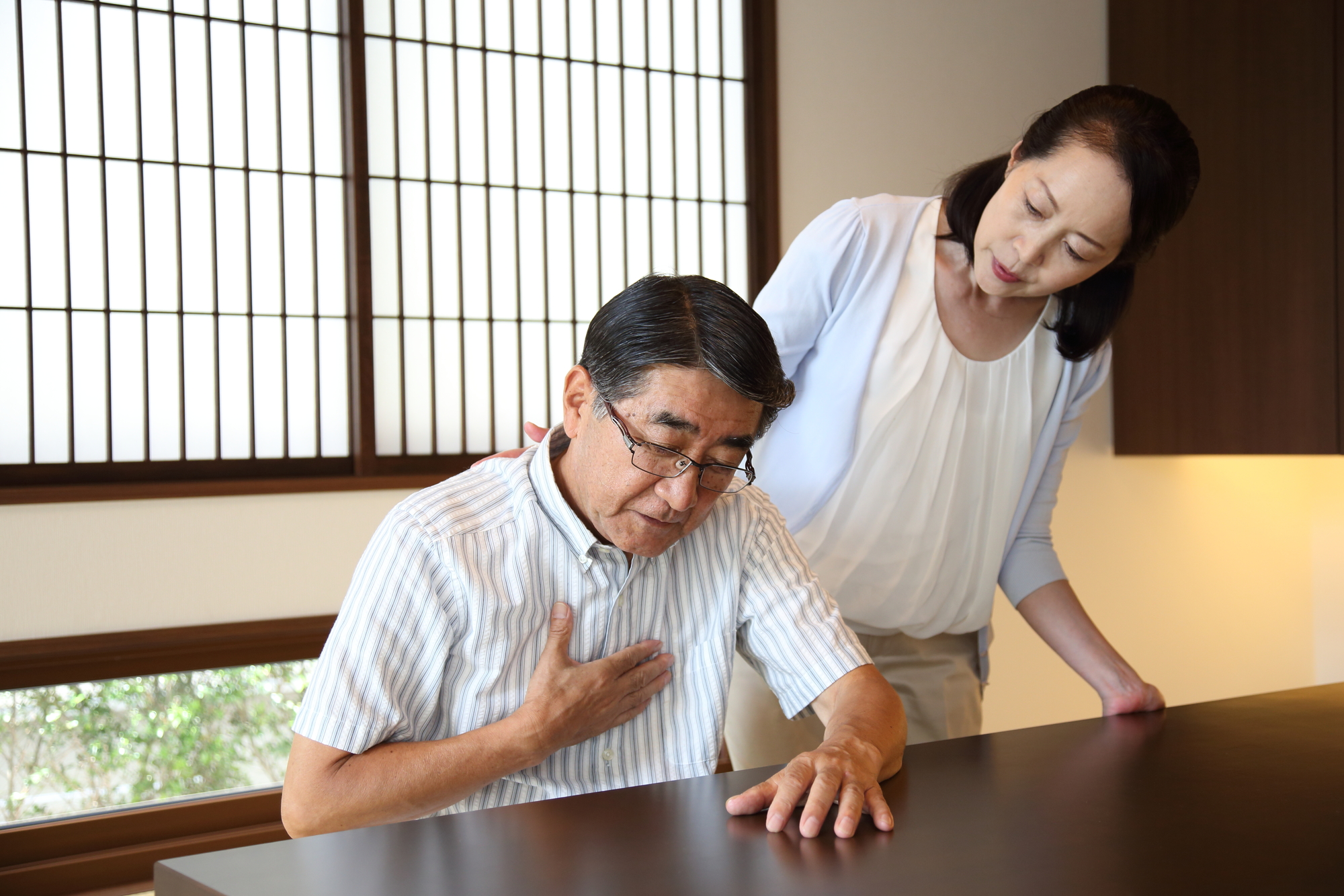 体調不良の中年男性を心配する女性