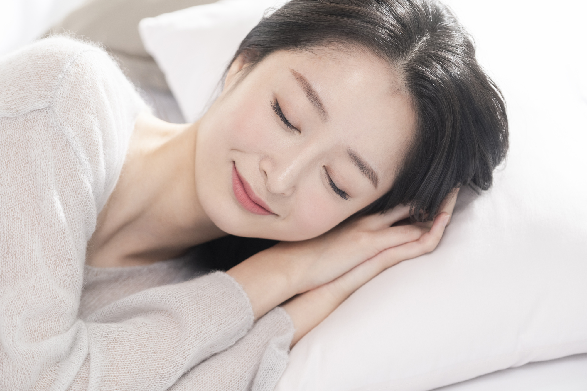 微笑みながら眠っている若い女性