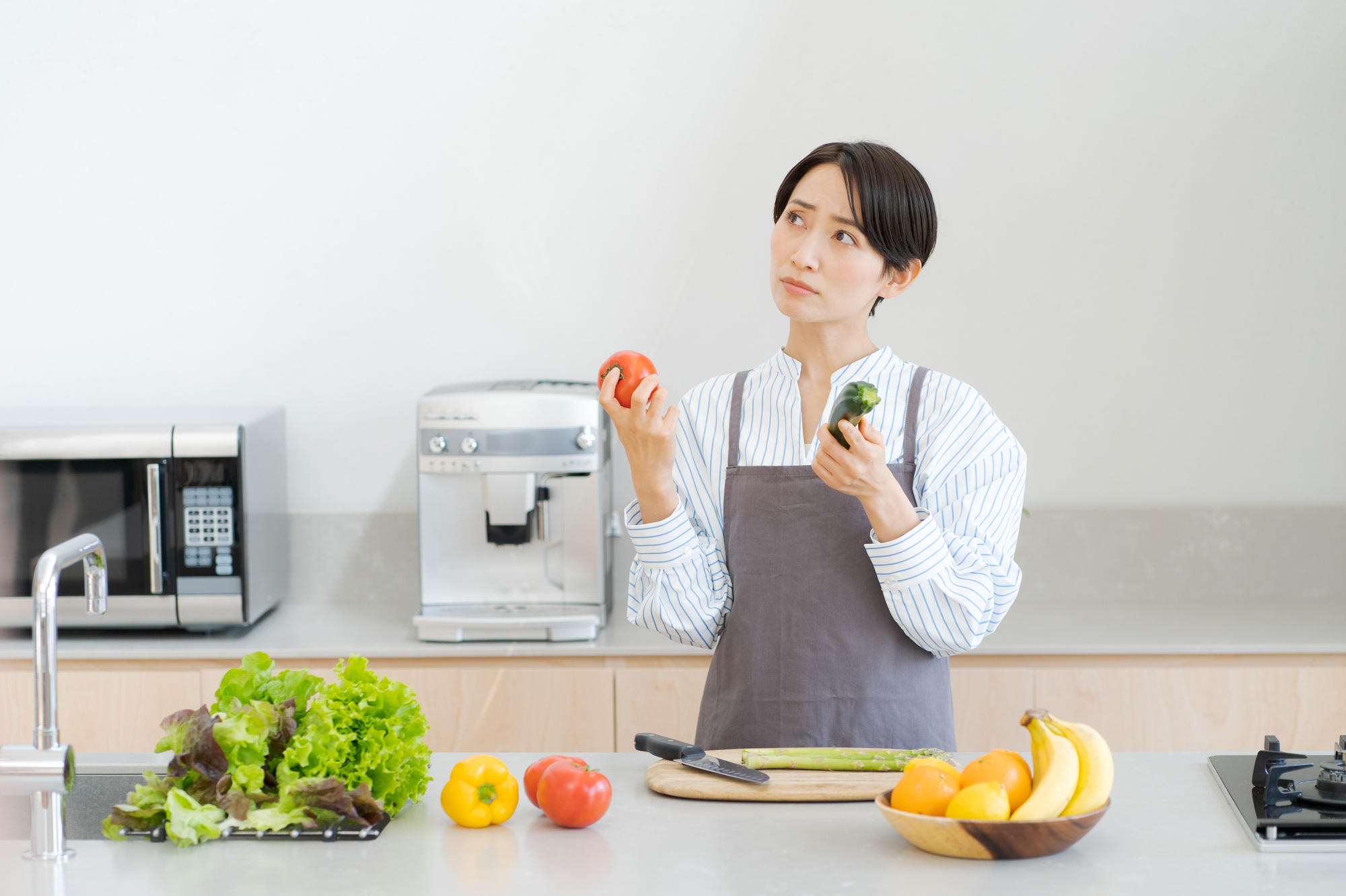 キッチンで悩む女性