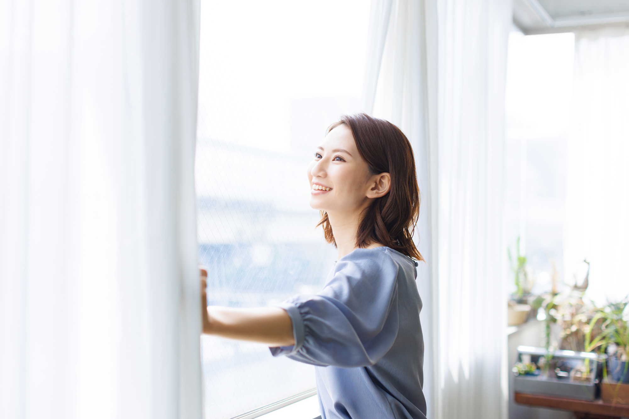 カーテンを開ける女性