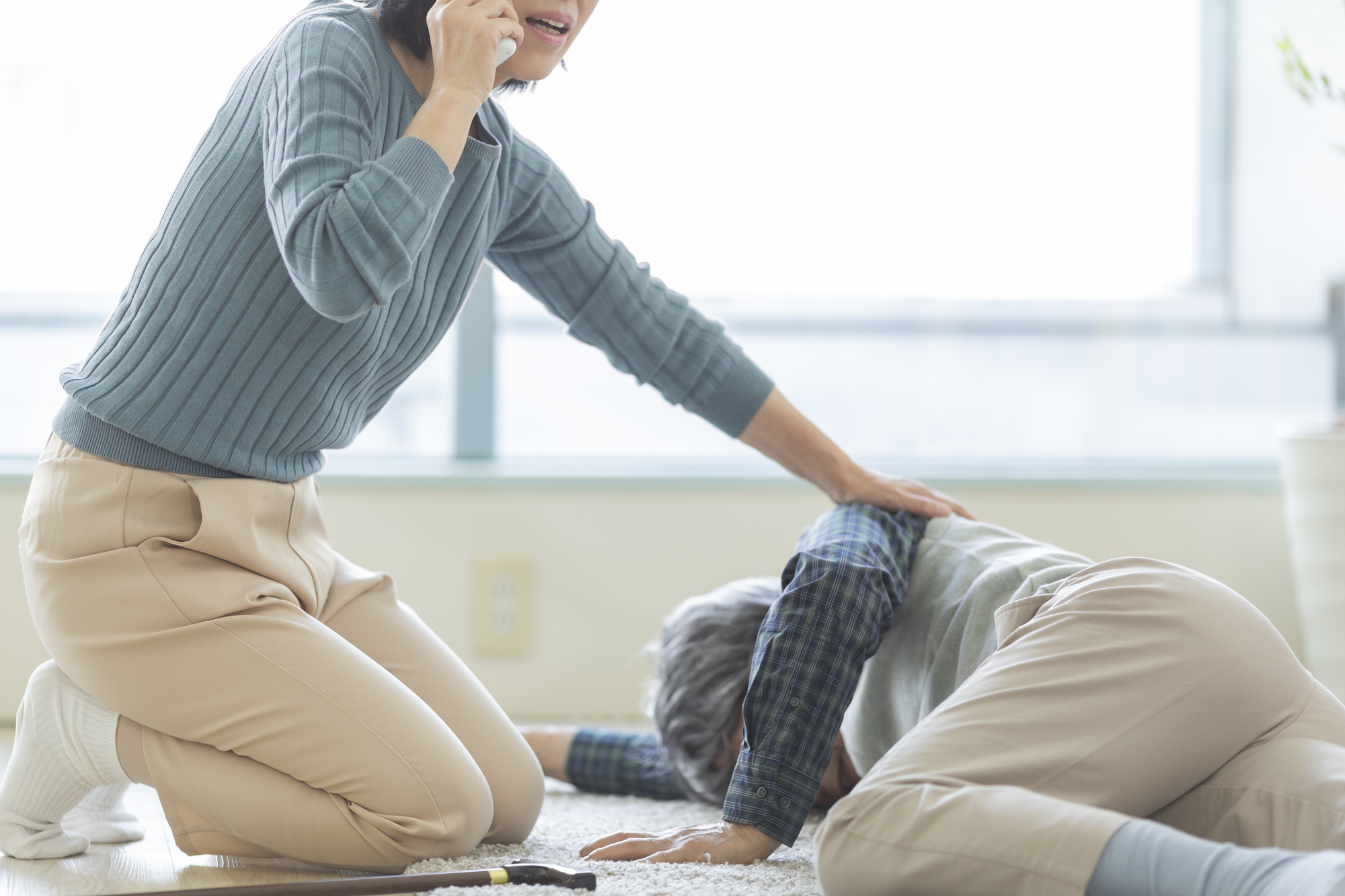 倒れている高齢女性と心配する女性