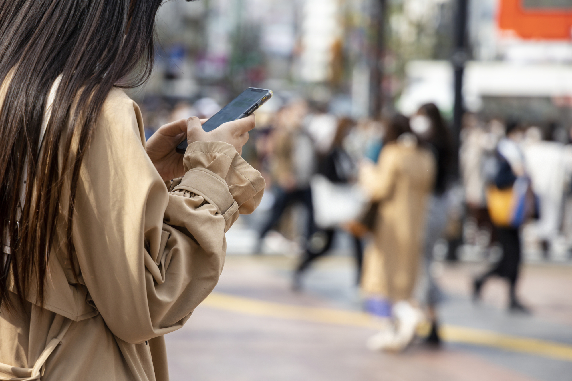 街中でスマホをいじる女性