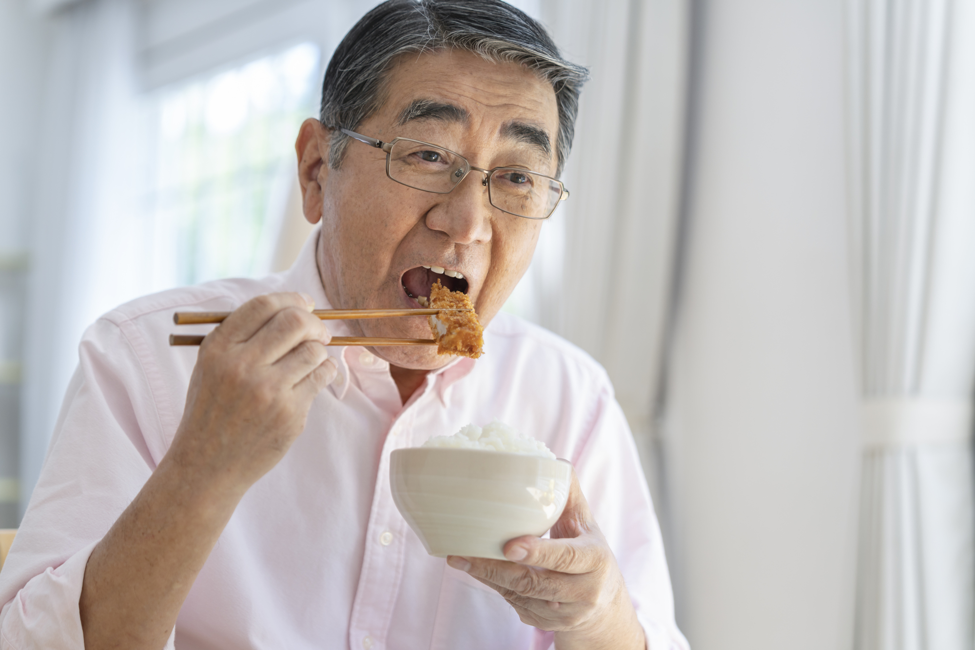 とんかつを食べる中年男性