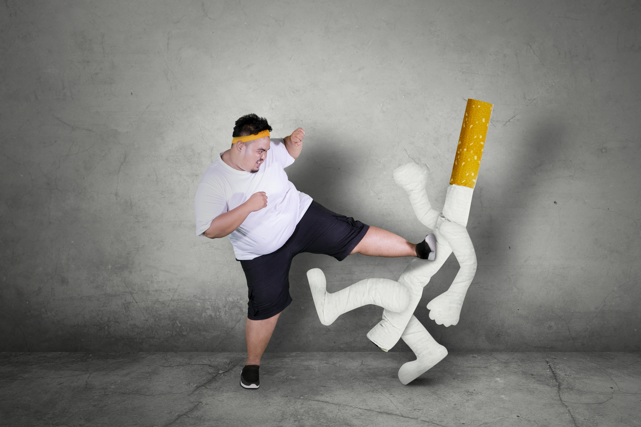 タバコのイメージを蹴る肥満男性