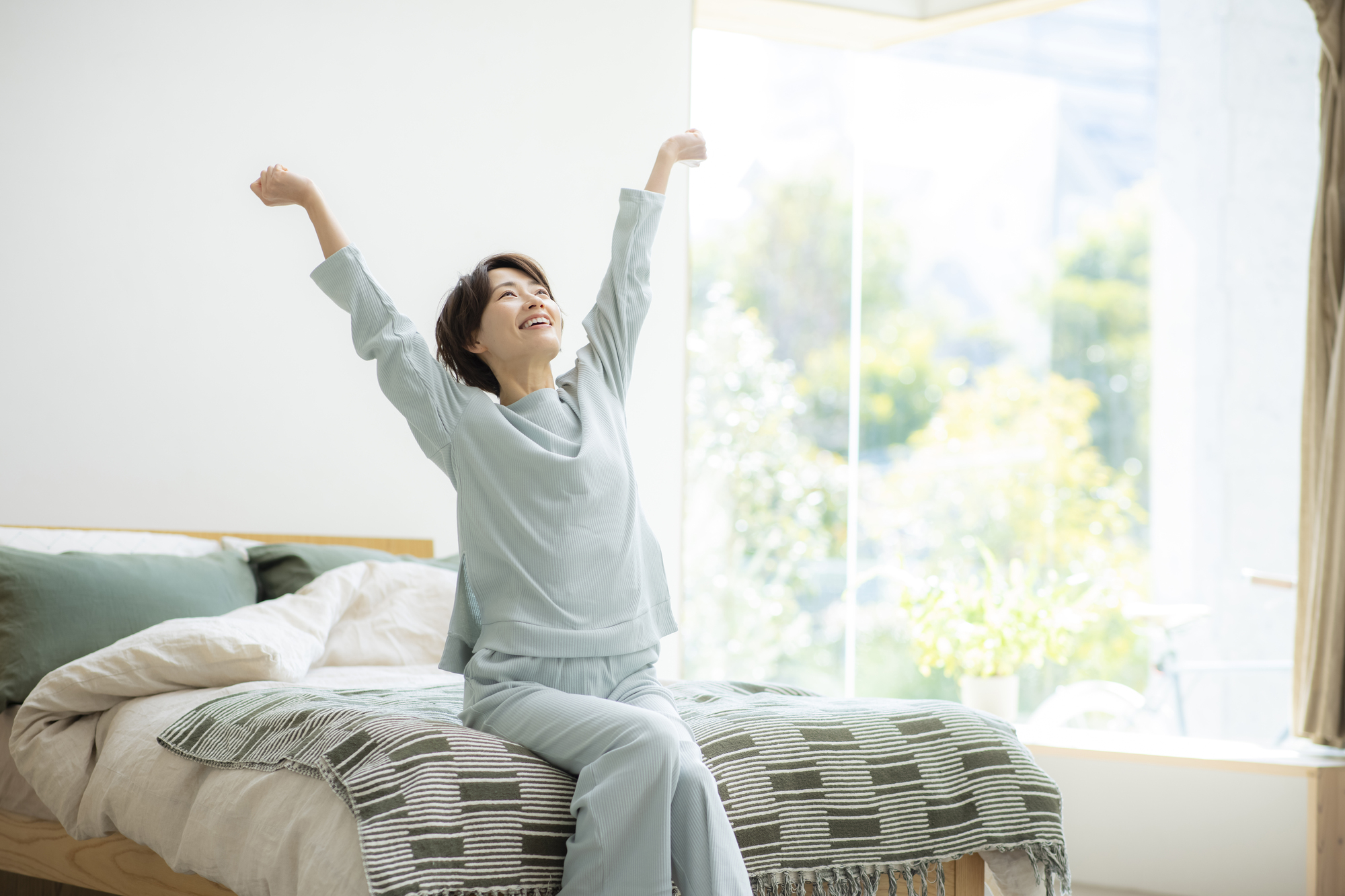 伸びをする寝起きの女性