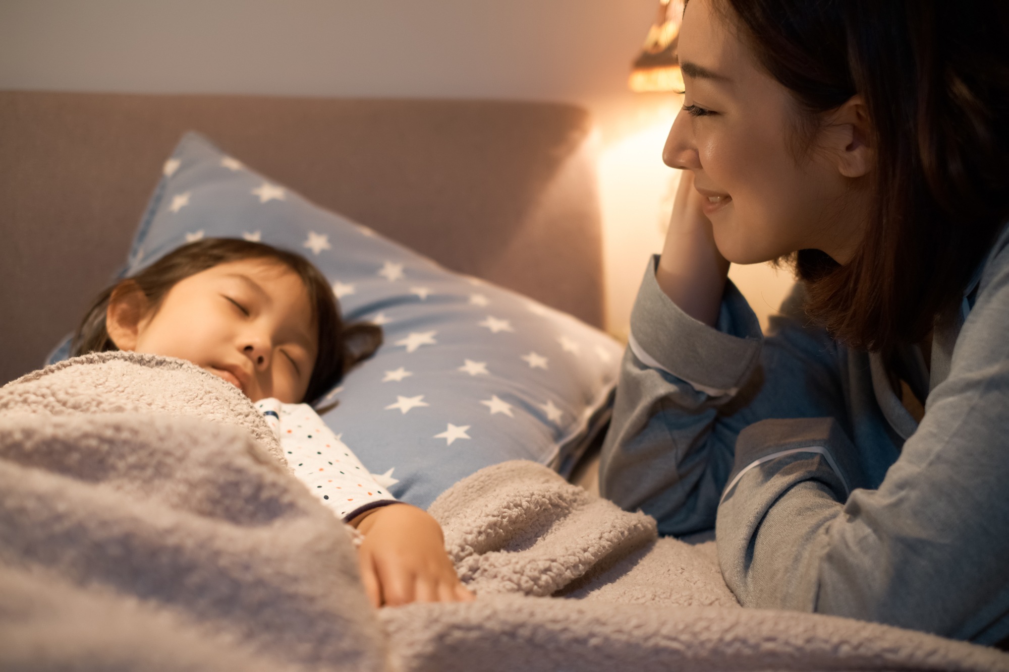 子どもを寝かしつける親