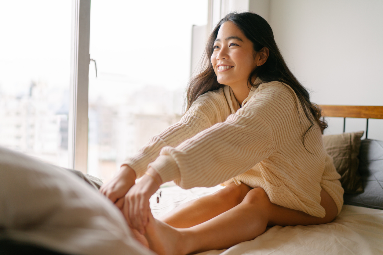 ベッドの上でストレッチをしている女性